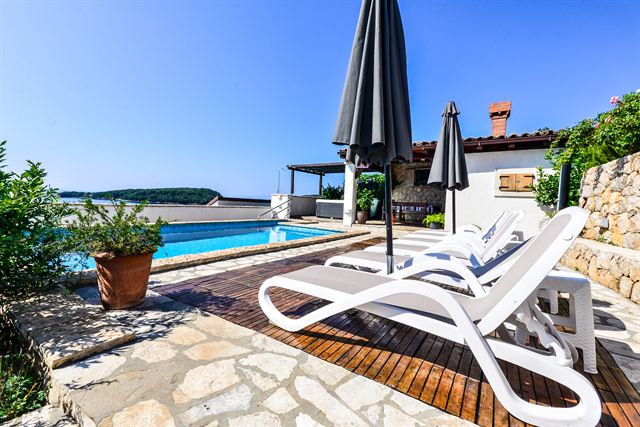 Pool terrace with sun loungers and parasol