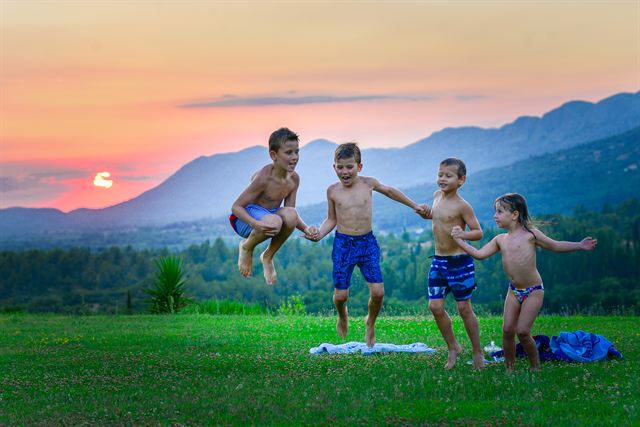 Children playing on the lawn at sunset